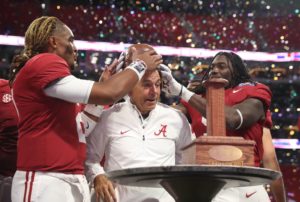 Sep 2, 2017; Atlanta, GA, USA; Alabama Crimson Tide quarterback Jalen Hurts (2) and Bo Scarbrough (9) put the old leather helmet on head coach Nick Saban after defeating the Florida State Seminoles 24-7 in the 2017 Kickoff Game at Mercedes-Benz Stadium. Mandatory Credit: Jason Getz-USA TODAY Sports